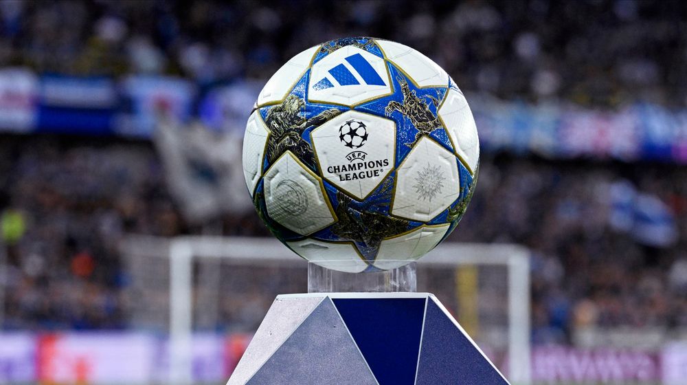 Adidas Champions League soccer ball on a display stand in a stadium.