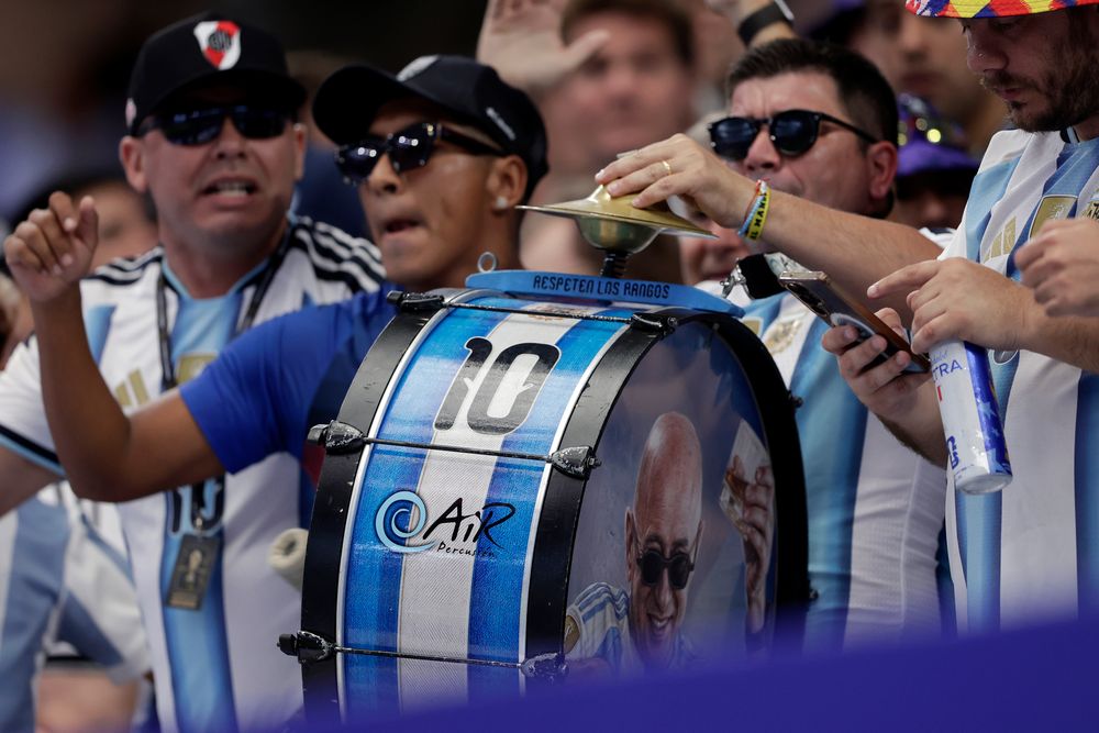 Enthusiastic fan plays an Argentinian flag drum with number 10 for cheering supporters.